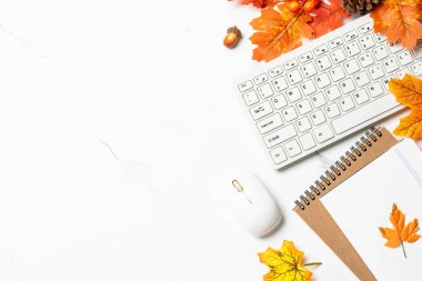 Sonbahar çalışma alanı. Dizüstü bilgisayar, defter ve dökülen yapraklar. Metin için alanı olan düz resim.