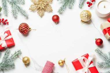 Beyaz üzerine Noel kompozisyonu. Noel kırmızı, altın madalyalar ve köknar ağacı. Kopyalama alanı olan üst görünüm.