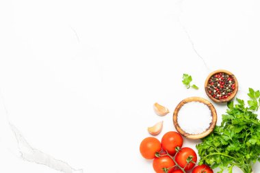 Mutfak masasında otlar, baharatlar ve sebzeler. Yemek pişirme arka planı beyaz ve tasarım için alanı var.