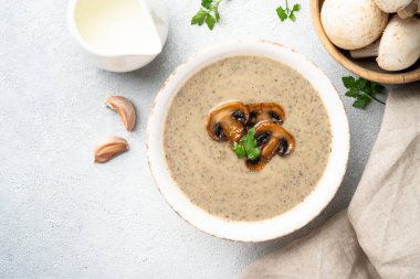 Beyaz mutfak masasında mantar çorbası püresi. Sağlıklı vejetaryen yemeği. Üst görünüm.