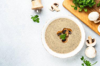 Beyaz mutfak masasında mantar çorbası püresi. Sağlıklı vejetaryen yemeği. Üst görünüm.