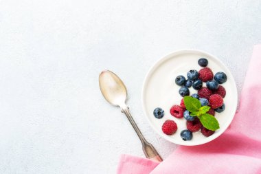 Beyaz arka planda taze böğürtlenli yoğurt. Sağlıklı atıştırmalıklar ya da kahvaltı. Tasarım için alanı olan üst görünüm.