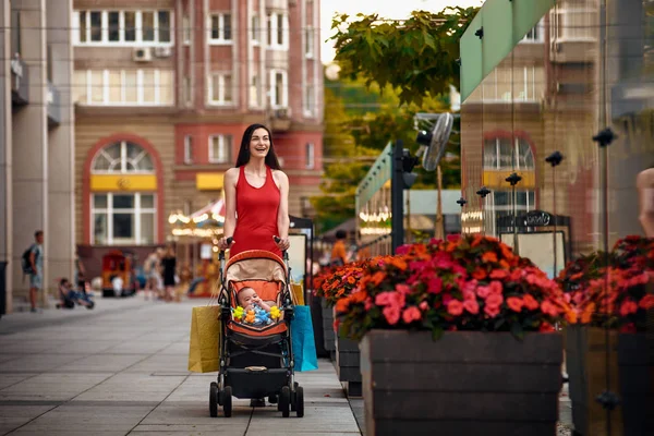 Мати з дитячою коляскою на міській вулиці літо — стокове фото