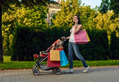 Kadın ile bebek arabası kullanarak cep telefonu yürüyüş