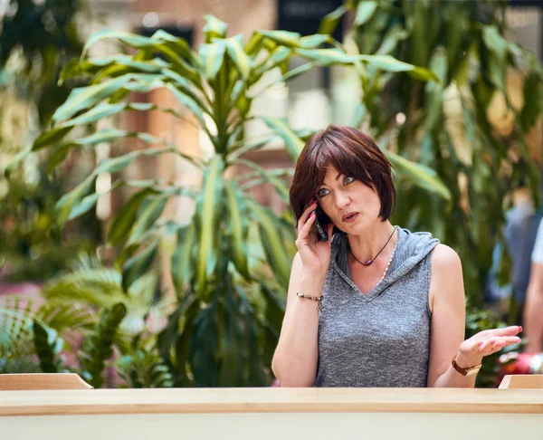 Mature female talking smartphone — Stock Photo, Image