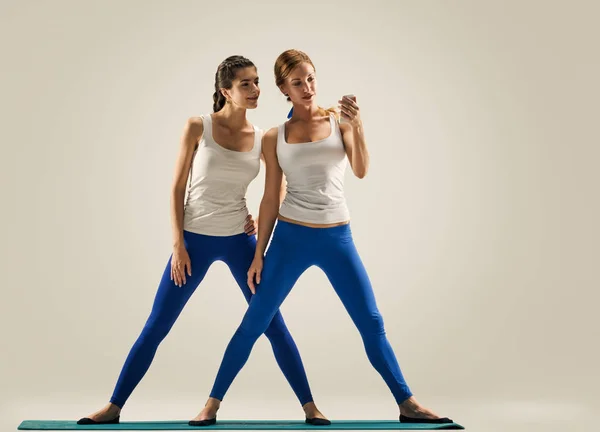 Chicas de yoga disfrutan con smartphone — Foto de Stock