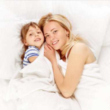 mutlu anne ve kızı yatakta