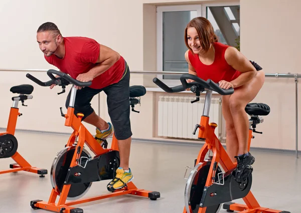 Cuplu ciclism cu bicicleta în sala de gimnastică — Fotografie, imagine de stoc
