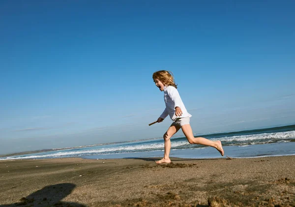 Menino correndo na praia — Fotografia de Stock