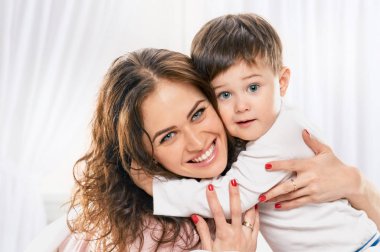 küçük çocuk kucaklayan mutlu anne