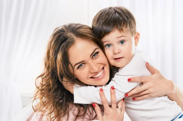 küçük çocuk kucaklayan mutlu anne