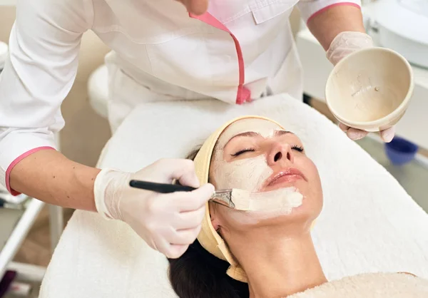 Cosmetician applying facial mask — Stock Photo, Image