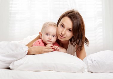Mutlu aile anne ve bebek yatakta eğleniyor