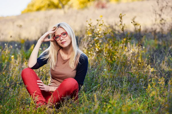 Blondýna v podzimní trávě — Stock fotografie