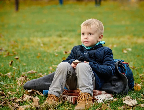 Çimlerde oturan çocuk — Stok fotoğraf