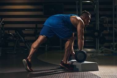 Adam exercesing dumbbells ile