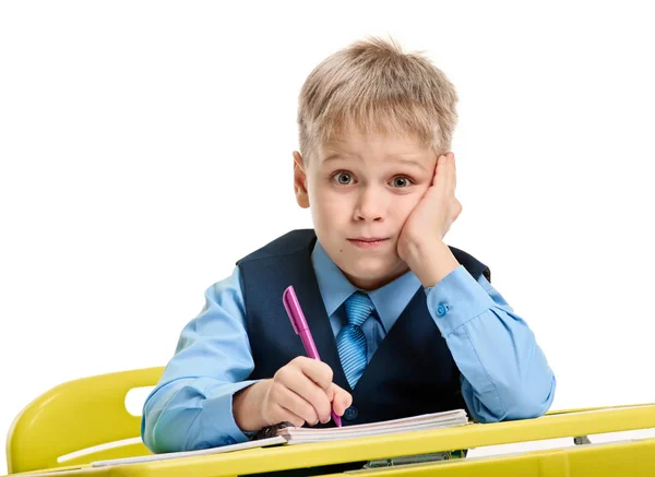Bored schoolboy writing — Stock Photo, Image