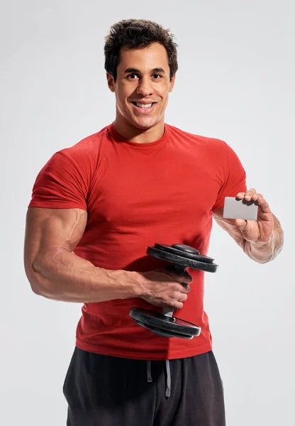 Boş oyun kağıdı ile güçlü ve güç vücut geliştirmeci — Stok fotoğraf