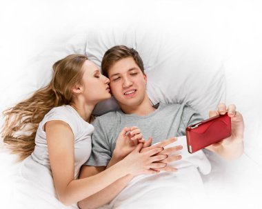 İki mutlu aşıklar yatakta yatan selfie yapma