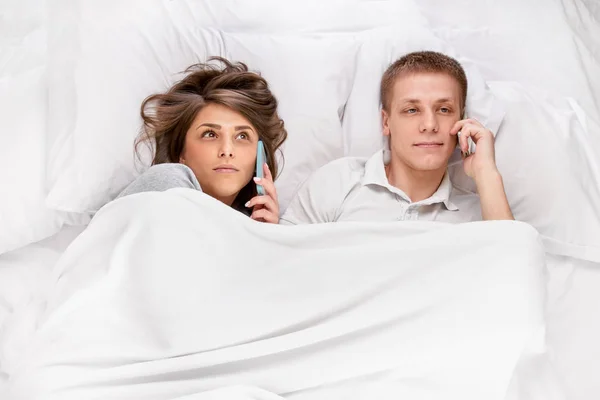 Persoanele cu smartphone-uri în pat — Fotografie, imagine de stoc