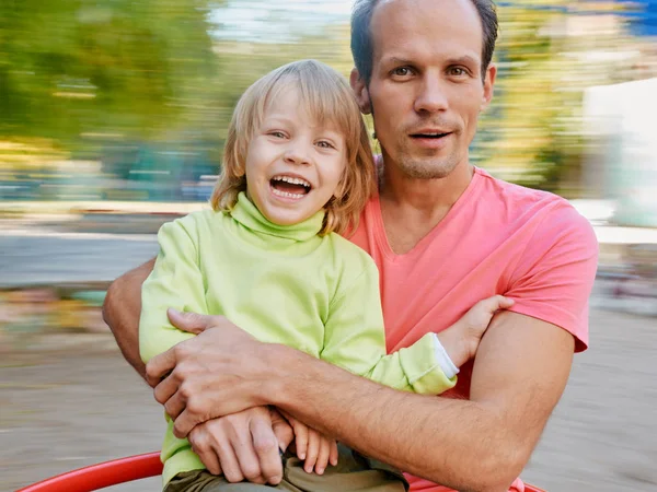 Glücklicher Vater und Sohn auf dem Karussell — Stockfoto