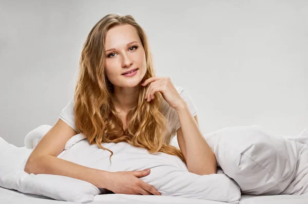 Aantrekkelijke blonde meisje in bed — Stockfoto