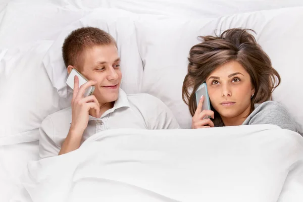 Menschen mit Smartphones im Bett — Stockfoto