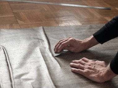 Marangozların elleri birbirine yapışkan filmden havayı temizliyor.