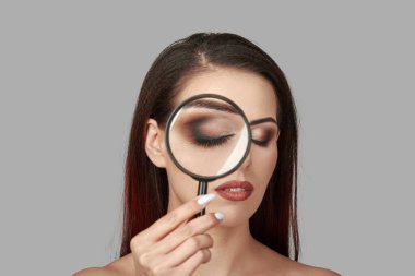 Büyüteçle bakan genç ve güzel bir kadın