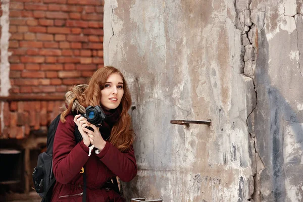 Genç ve çekici bir kadın şehrin kış manzarasının fotoğraflarını çekiyor, genç bir kadın şehrin kış manzaralarını merceğiyle yakalıyor..
