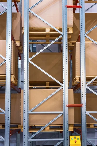 Large cardboard boxes on shelves of metal shelving.