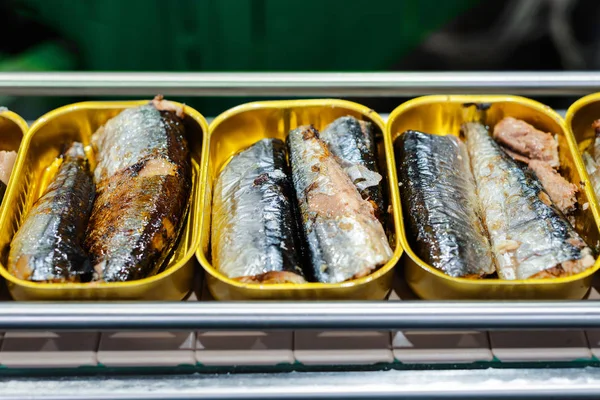 Tin cans with fish on the conveyor.