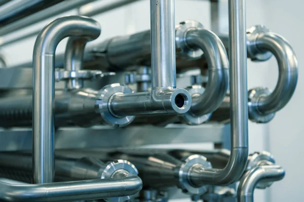 Industrial stainless steel piping connected by special nuts.