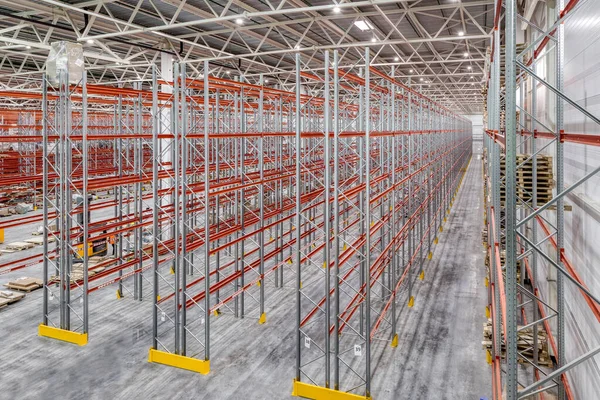 Large warehouse. Tall and long metal shelving.