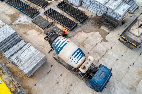 A concrete mixer truck transports concrete through a construction site.