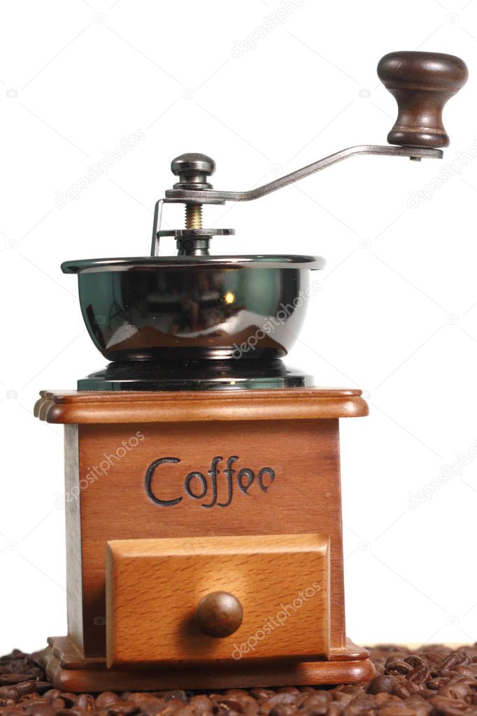 Manual coffee grinder and coffee beans scattered