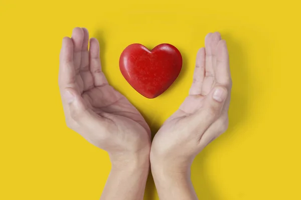 Manos que sostienen el corazón rojo, la salud del corazón y el concepto de donación —  Fotos de Stock