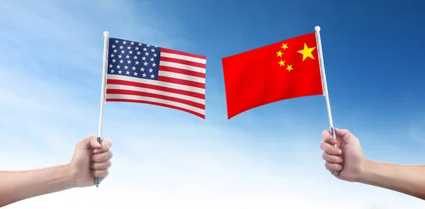 Hand holding american flag and china flag in a hand