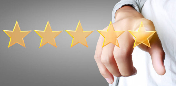 Рука трогательного подъема на увеличении пяти звезд. Повышение рейтинговой оценки и концепции классификации