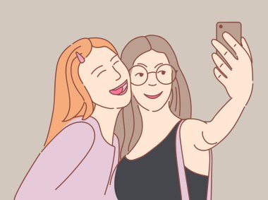 akıllı telefon ile selfie çeken iki mutlu genç kız