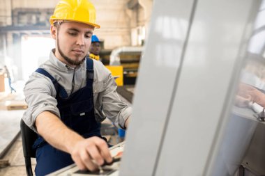 Sarı hardhat konveyör bant fabrika Atölyesi'nde yönetirken için Denetim Masası ciddi konsantre sakallı makinesi operatörü