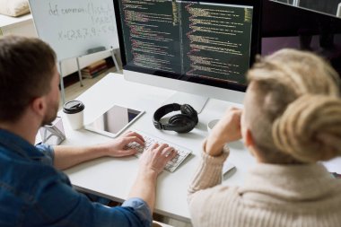 Yüksek açı bilgisayar kullanarak masada oturan kod yazma iki çağdaş program geliştiriciler portresi görüntülemek ve başlangıç projesi modern ofis, birlikte çalışma alanı kopyalama