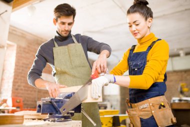 Modern mobilya fabrikası içinde erkek meslektaşı ile çalışırken kadın esnaf kesim ahşap gülümseyen portresi