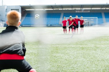 Kaleci, kopya alanı arkadan görünüm ile Kapısı'nın net üzerinden vurdu açık stadyum, futbol oynayan genç çocukların tam uzunlukta portresi