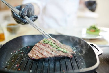 Modern Restoran mutfağında, kopya alanı pişerken tavada et pişirme tanınmaz profesyonel Chef yakın çekim