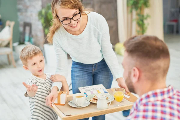 妻と息子の家庭で父の日を祝っているお父さんの驚き朝食をもたらすの暖かいトーンの肖像 — ストック写真