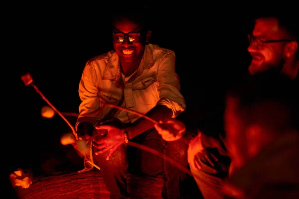 Vrolijke Happy Afrikaanse Jongeman Brillen Marshmallow Roosteren Tijdens Een Gesprek — Stockfoto