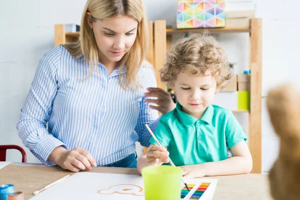 Ragazzino Disegno Immagine Con Vernice Con Insegnante Aiutandolo Nella Lezione — Foto Stock