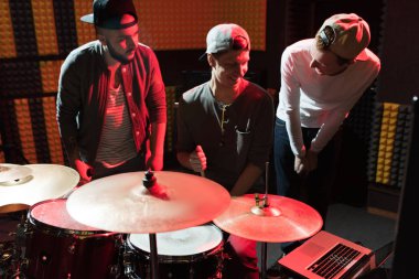 Bel kadar loş kayıt stüdyosunda prova yaparken yumruk arkadaş darbeleme dövmeli modern şarkıcı portresi