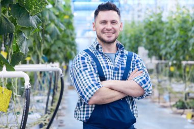 Bel portre silah ile ayakta poz neşeli çiftlik işçisi kadar geçti ve sera kamerada bakarak, uzay kopyalayın